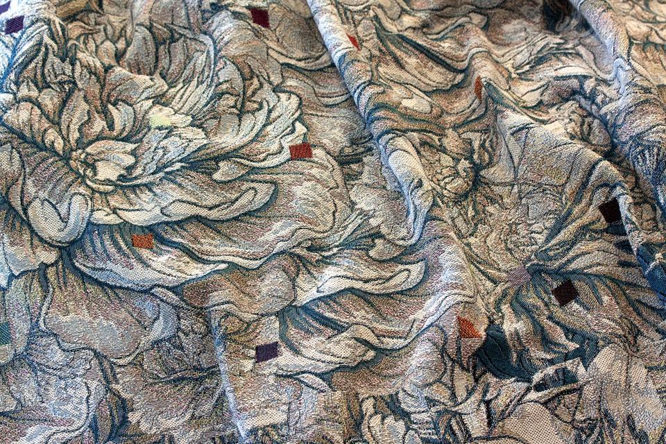 A textile woven in muted tones in a floral pattern