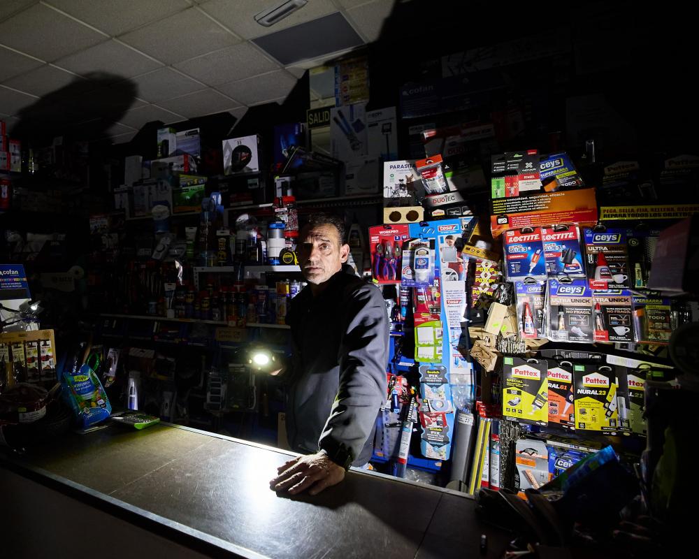 A shopkeeper in Granada, Spain, stays open in a blackout by using a torch
