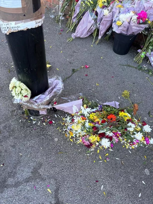 The flowers and messages have been ripped from the post