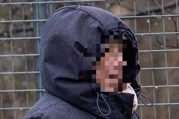 An image of a person wearing a black hooded coat. Their face is pixelated.