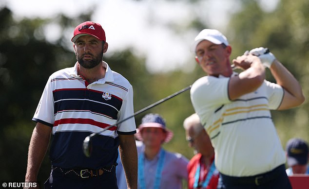 Golf - The 2025 Ryder Cup - Bethpage Black Golf Course, Farmingdale, New York, United States - September 28, 2025 Team Europe's Rory McIlroy hits his tee shot on the 2nd hole during the singles as Team USA's Scottie Scheffler looks on REUTERS/Paul Childs