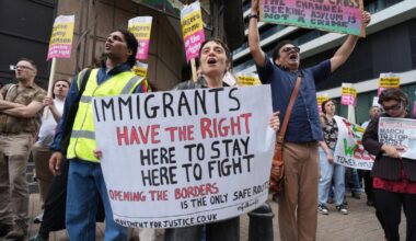 Protestors gather outside the Britannia Hotel in Canary Wharf