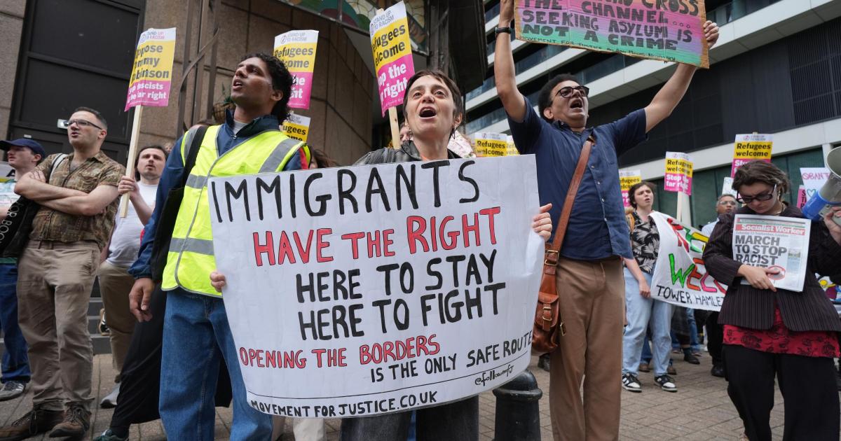 Protestors gather outside the Britannia Hotel in Canary Wharf