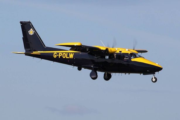 General view of National Police Air Service aircraft G-POLW. It is yellow and black in colour and is a tiny plane built for stealth