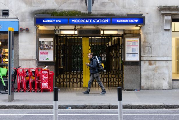 A commuter passes a shuttered entrance to Moorgate Underground Station