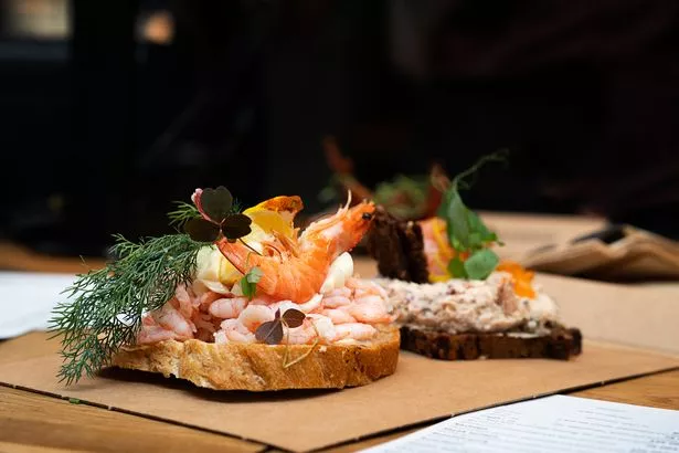 The traditional Danish open smorrebrod sandwich with rye bread and prawns