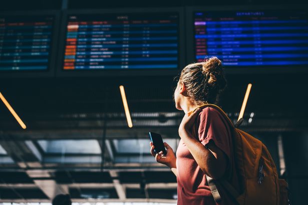 Woman checks airline schedule at airport.