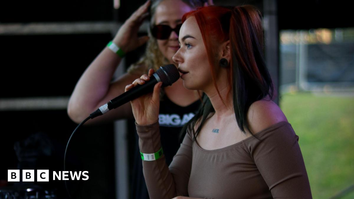April Stocks - stage name April-Ess - performing on stage with a mic in her hand.