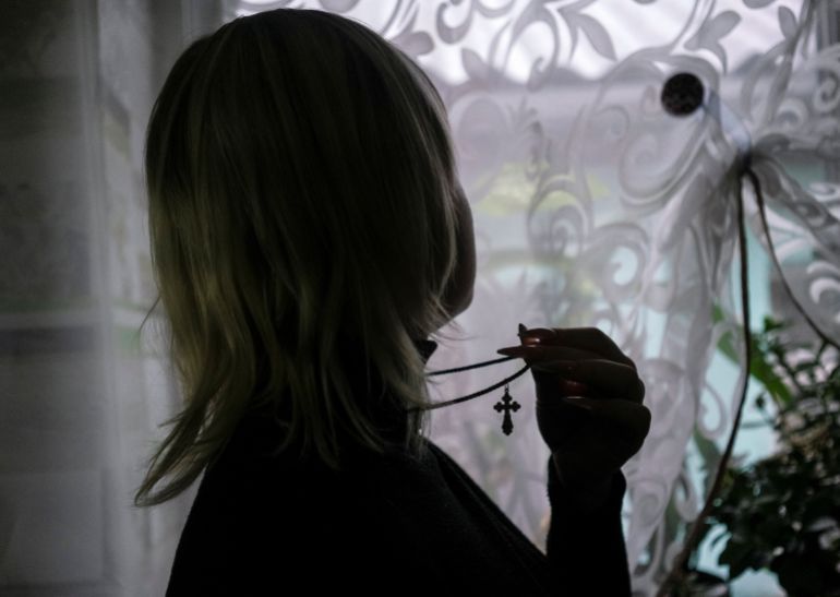 Olha 26-year-old, who says she was beaten, given electric shocks and subjected to forced nudity and torture by occupying Russian forces, holds her cross necklace, as she speaks with deputy head of Ukraine's war crimes unit for sexual violence, as Russia's attack on Ukraine continues, in Kherson, Ukraine, December 9, 2022. REUTERS/Anna Voitenko