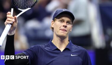 Jannik Sinner raises his racquet to the US Open crowd