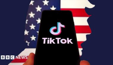 In this photo illustration, the logo of TikTok is displayed on a smartphone screen on April 5, 2025 in Shanghai, China. In the background is the American flag, cut  in the shape of Donald Trump's face.