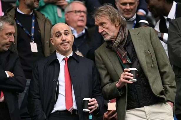 Manchester United's co-owner Jim Ratcliffe (R) leans over to speak with Manchester United's CEO Omar Berrada (L) during the English Premier League football match between Manchester City and Manchester United at the Etihad Stadium in Manchester, north west England, on September 14, 2025.