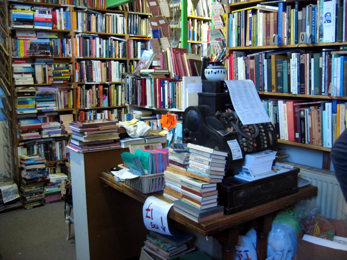 the inside of Osterley Bookshop with shelves and piles of books everywhere