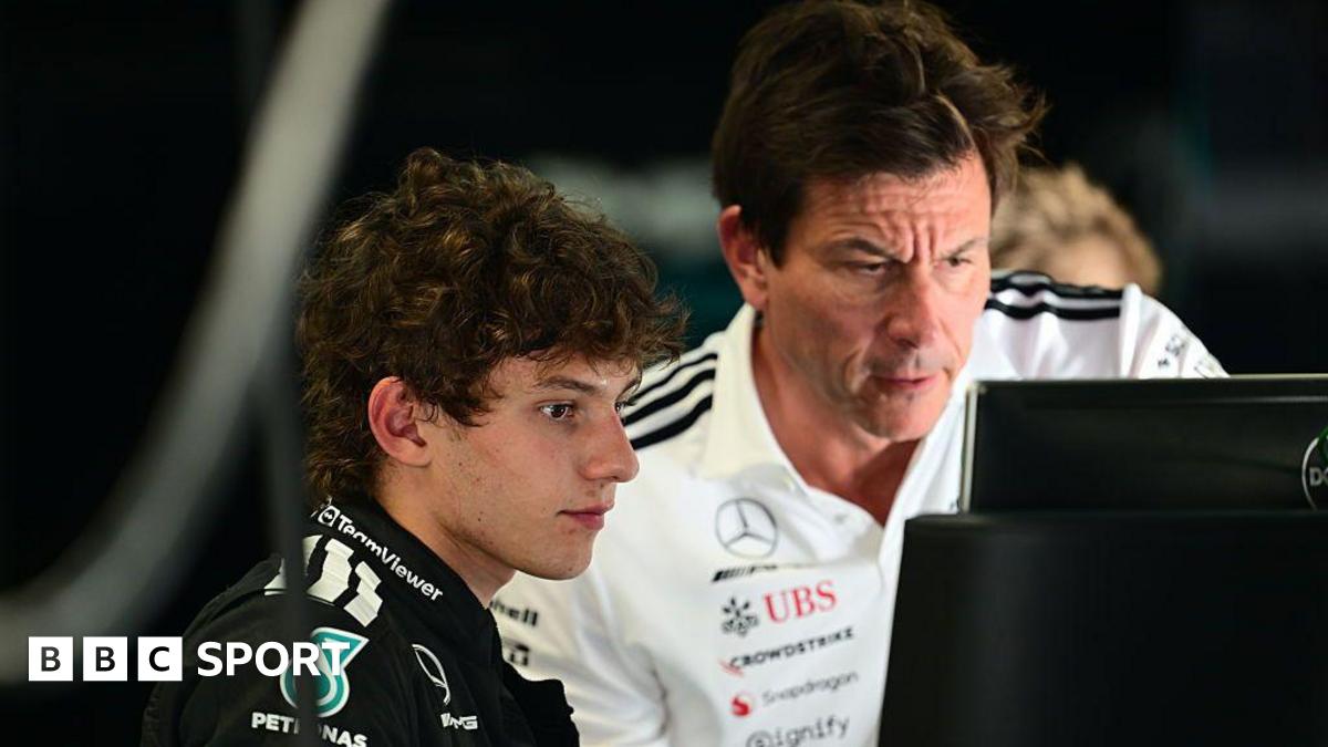 Kimi Antonelli and Mercedes boss Toto Wolff look at a computer screen at Monza