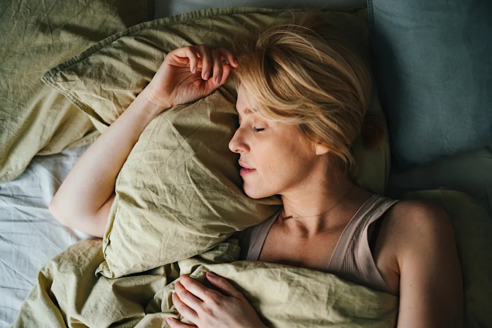 Top view of a beautiful blonde woman sleeping in bed. She looks peaceful and fast asleep.
