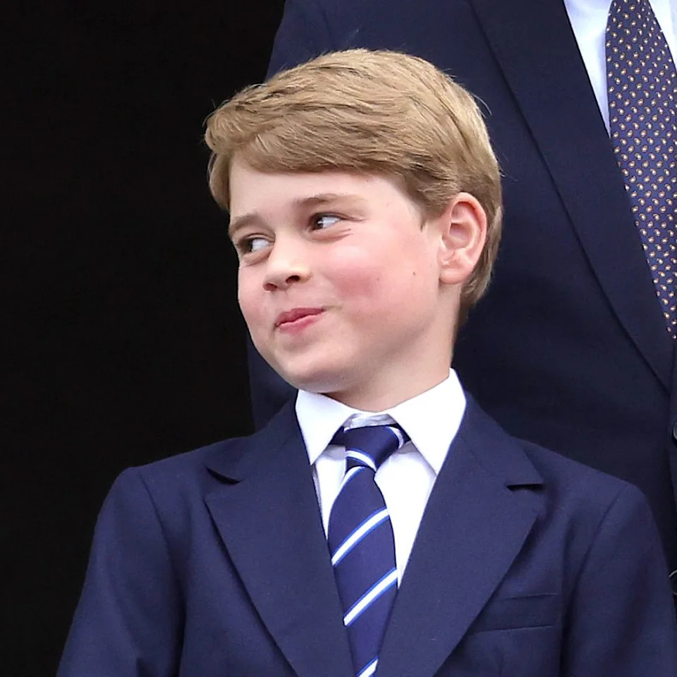  King Charles, Queen Elizabeth wearing bright green, and Prince George stand on the Buckingham Palace balcony. 
