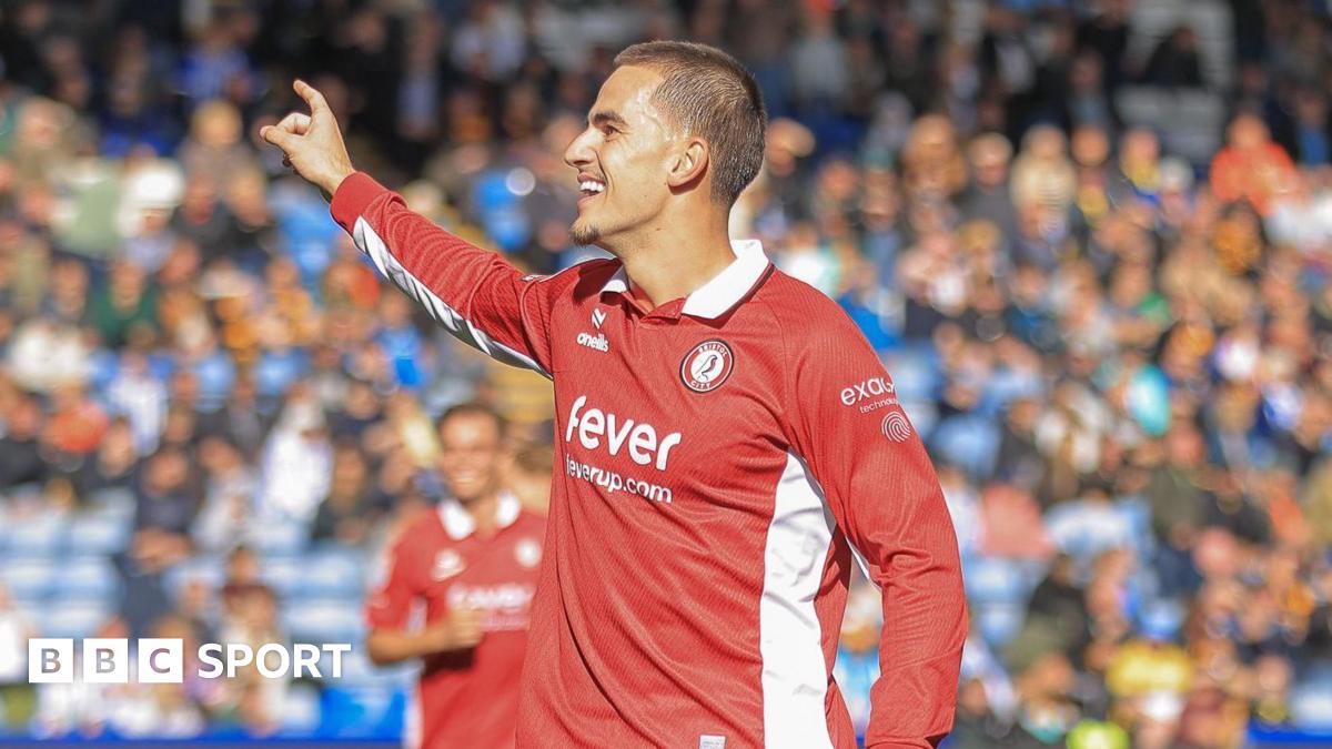 Anis Mehmeti holds his right arm out and points his finger and smiles