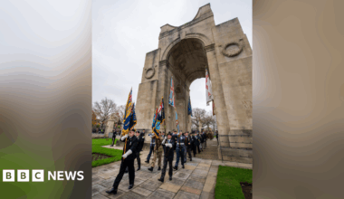 Soldiers and veterans holding flags in front of the Arch of Remembrance in Victoria Park, Leicester, for the Remembrance Sunday service on 9 November 2024.