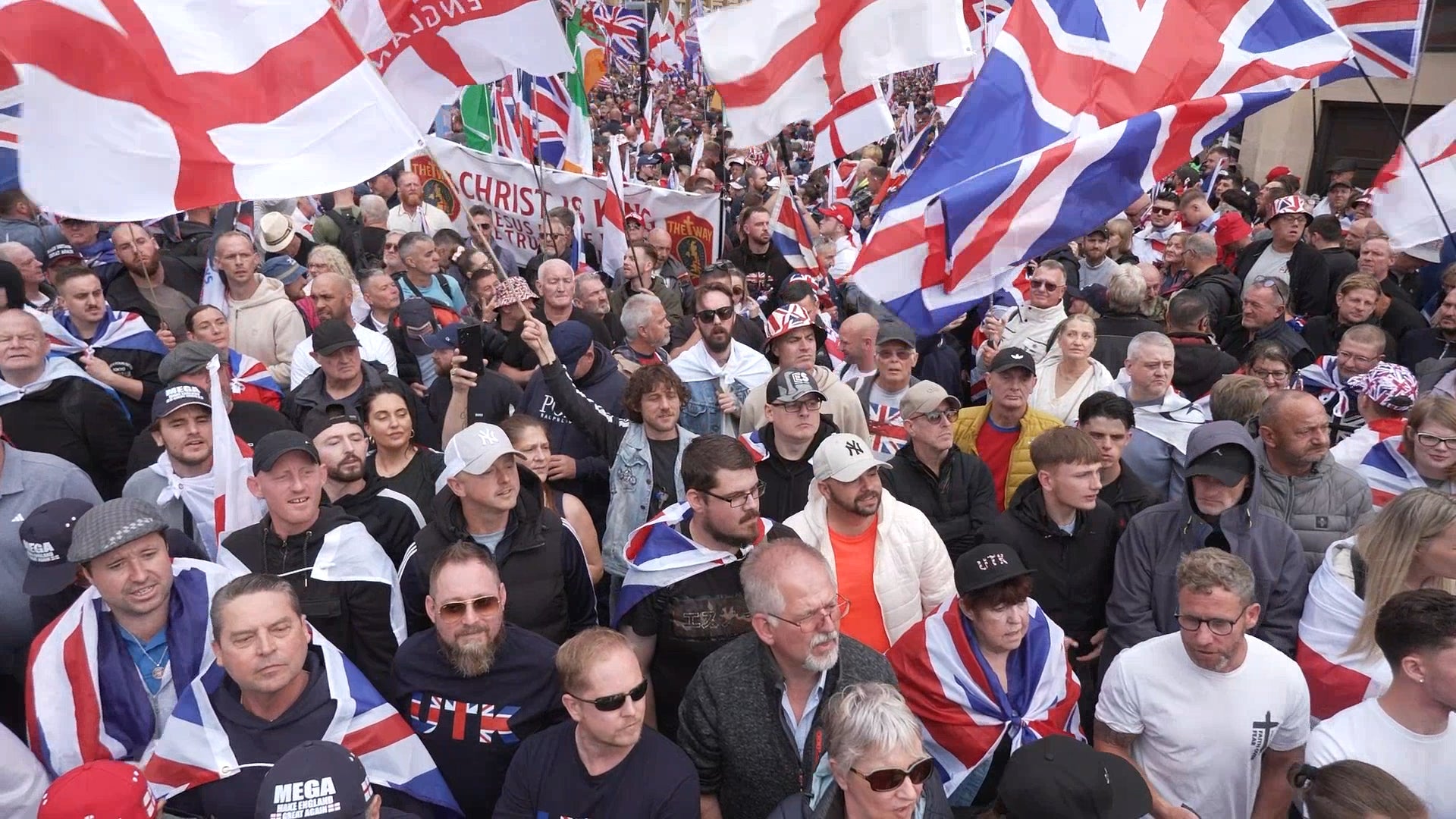 People fly union flags and the St George Cross during the Tommy Robinson-led march