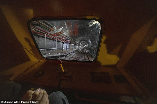 Visitors take a train ride to visit the cosmic detector located deep underground. The orb-shaped structure is filled with a liquid designed to emit light when neutrinos pass through