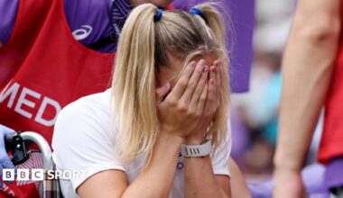 Molly Caudery covers her face with her hands as she's helped away from the track in a wheelchair