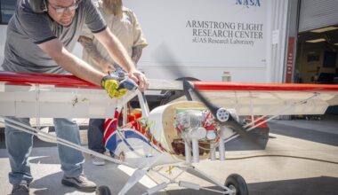 One man manages engine speed with a hand-held controller, while another firmly holds the subscale aircraft in place.