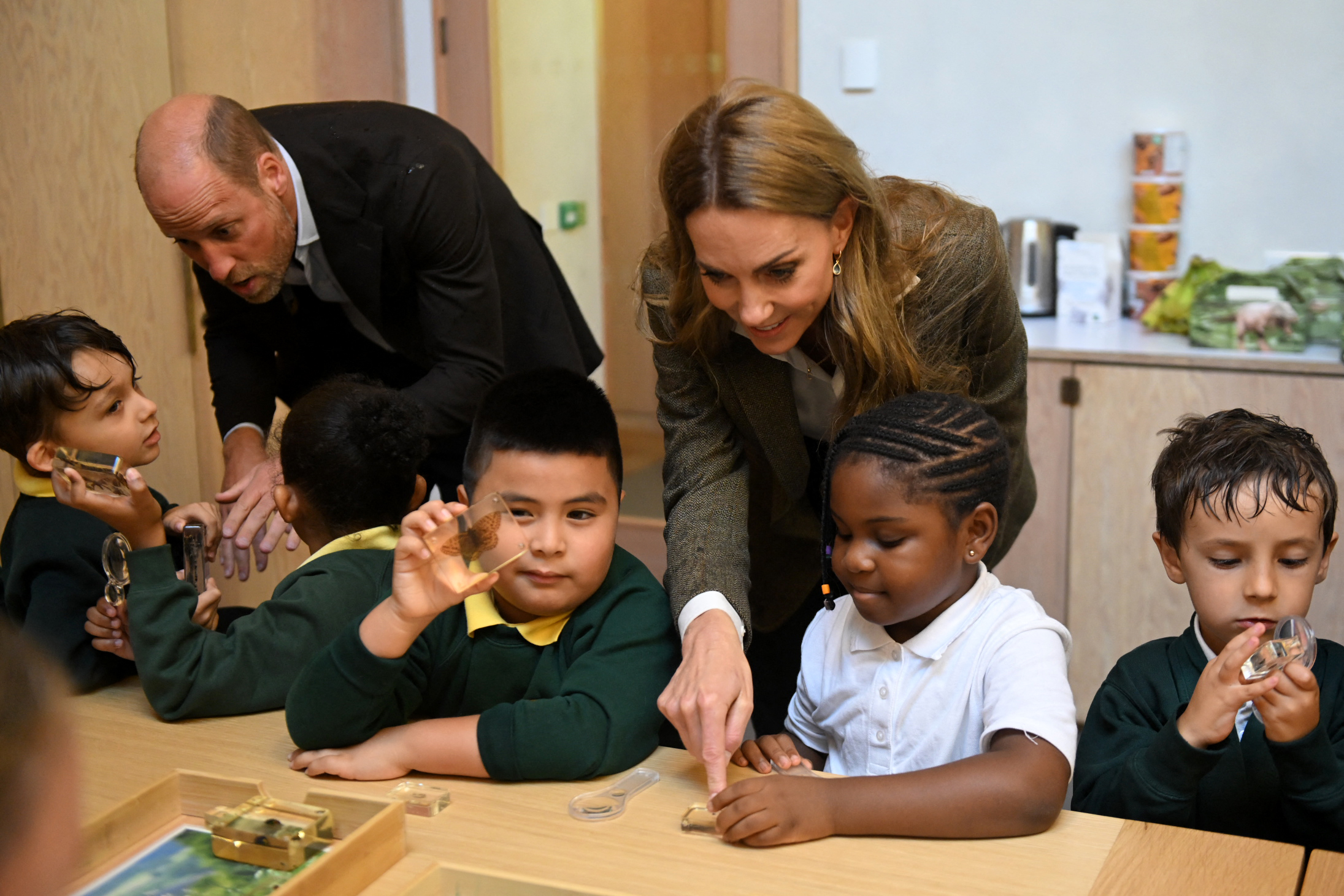 Prince William and Princess Kate helping kids with a craft at a table