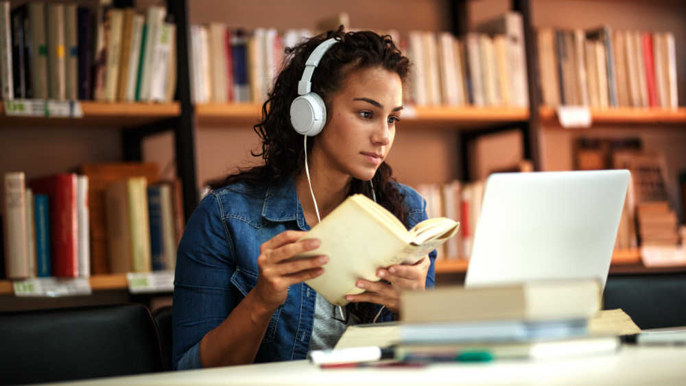 women wearing headphones and looking at computer
