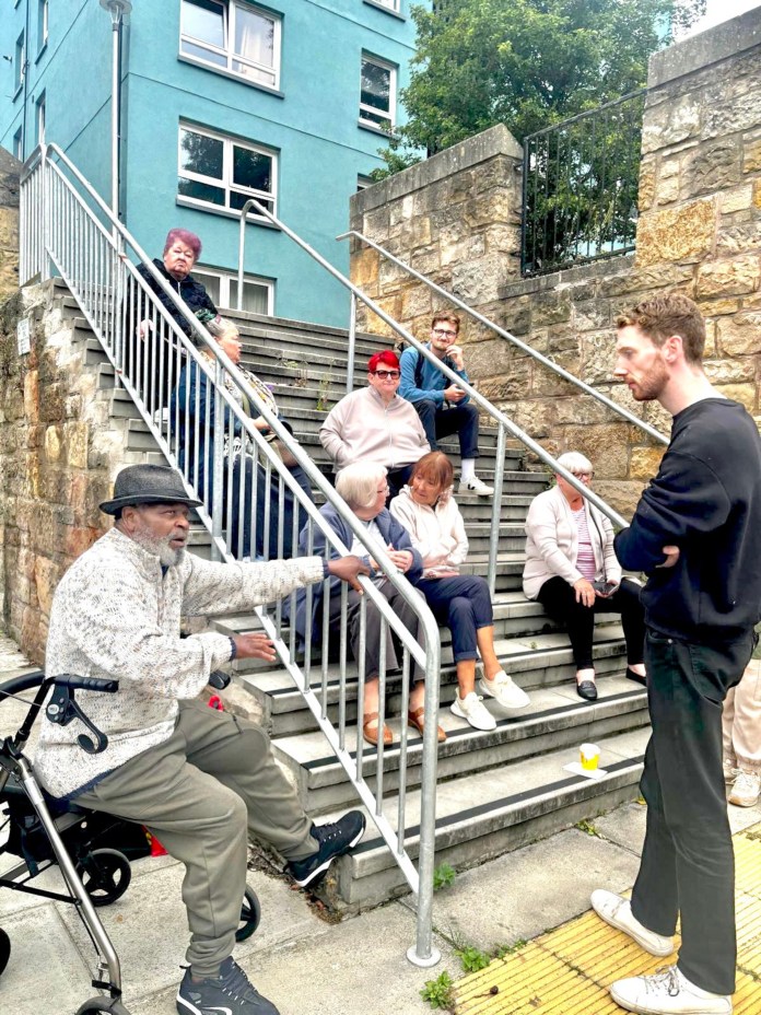 Chris Murray leading the impromptu meeting with his constituents on the steps outside the community centre (C) Chris Murray MP / X