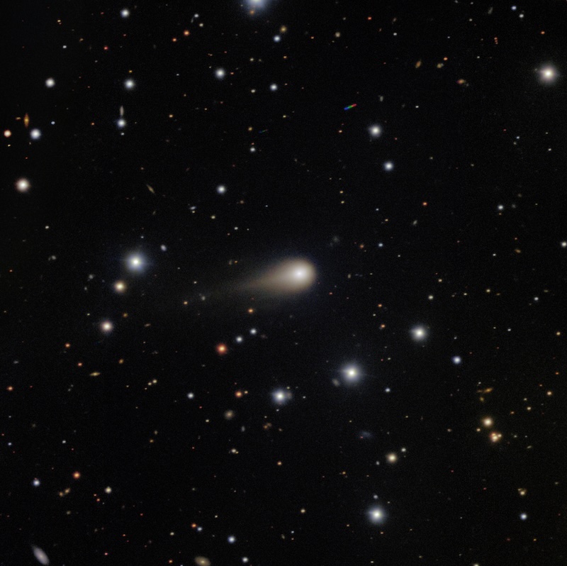 Starry background with a glowing ball in the center with a tail showing a comet.