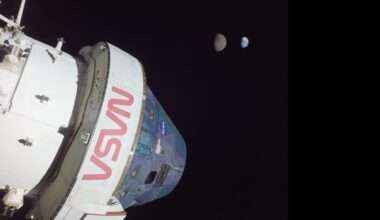 A large white space shuttle labeled in red &quot;NASA&quot; is seen in the darkness of space.