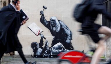 The mural depicts a protester lying on the ground holding a blood-splattered placard while a judge in a traditional wig and black gown beats him with a gavel.