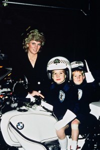 WINDSOR, UNITED KINGDOM - NOVEMBER 30:  Accompanied by Diana, Princess of Wales, Prince William aged 5 and Prince Harry aged 3 wear police helmets as they sit on a police motorbike during a visit to a police station on November 30, 1987 in Windsor, England (Photo by Anwar Hussein/Getty Images)