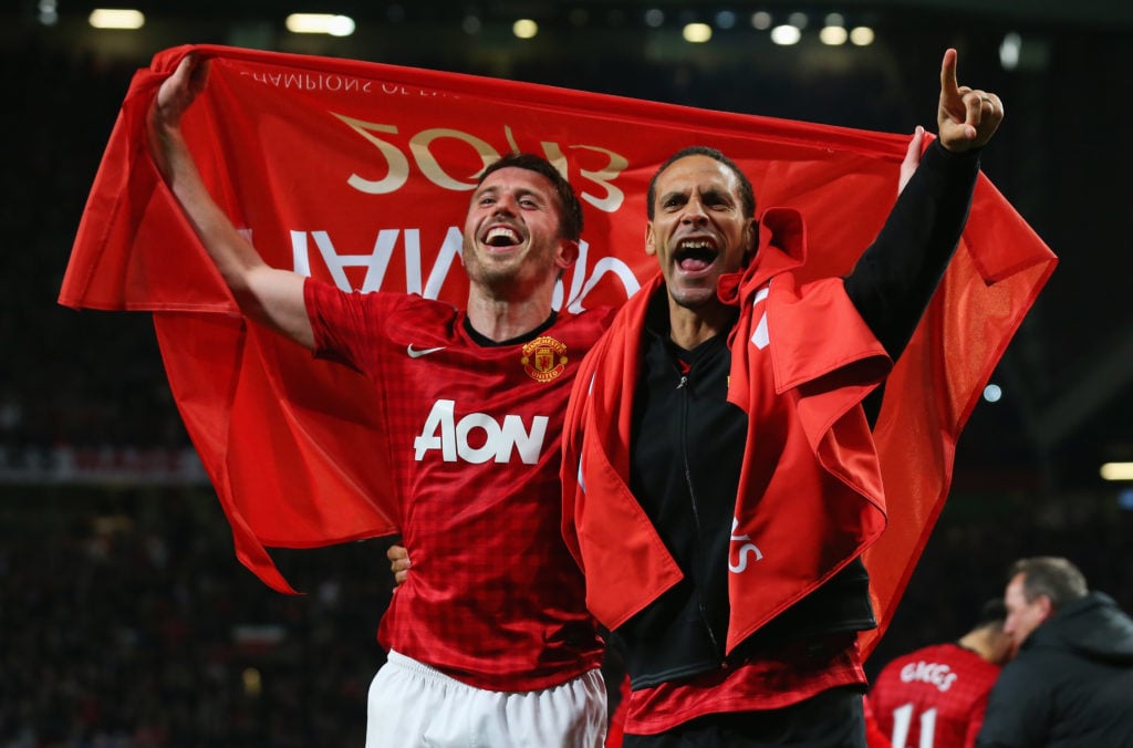 Rio Ferdinand celebrates winning 2013 title with Michael Carrick, holding Champions flag behind them