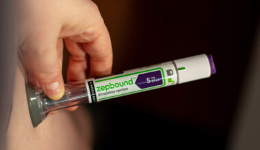 A photo of someone using a Zepbound injector pen on their stomach.