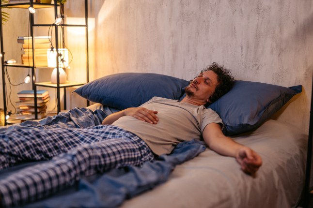 Mid-Adult Man Sleeping In The Bed At Night
