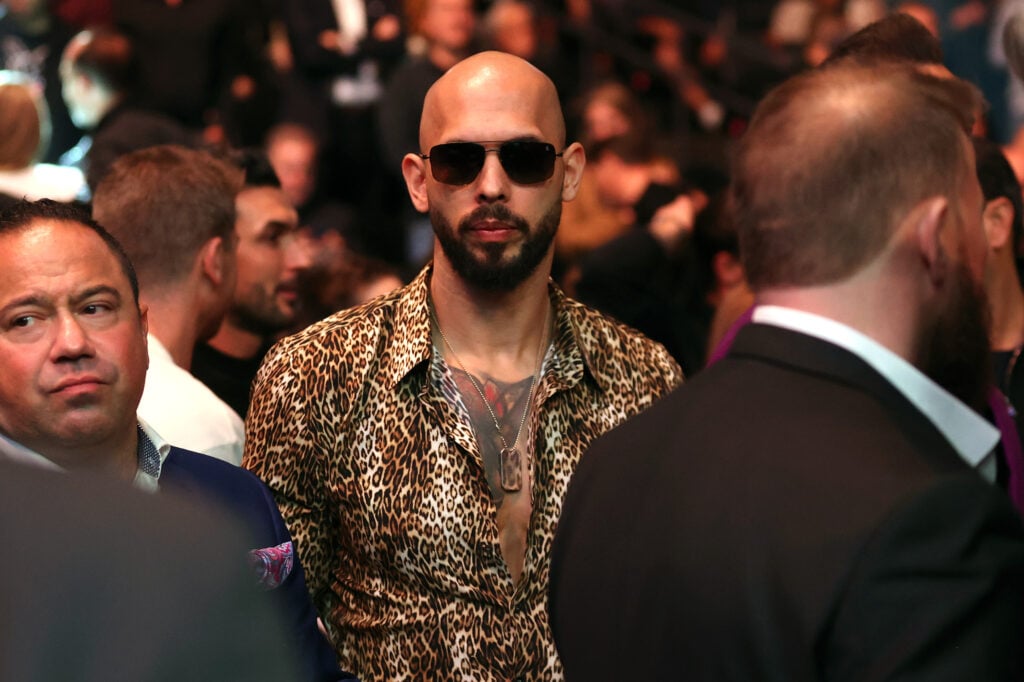 Andrew Tate wearing sunglasses attends a UFC event