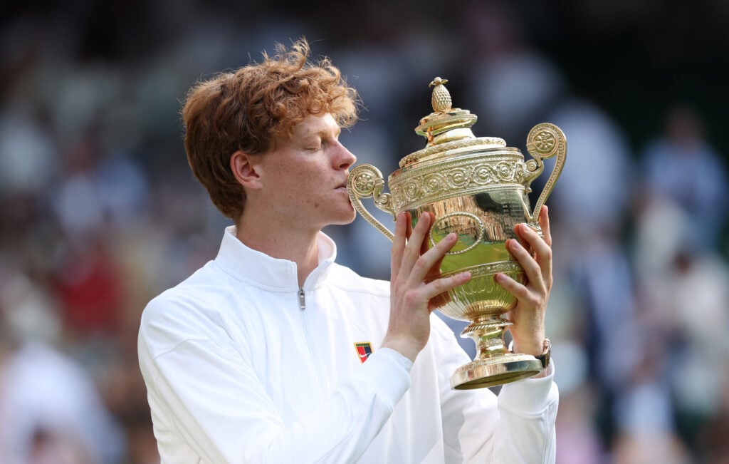 Jannik Sinner kisses the Wimbledon trophy after beating Carlos Alcaraz in the final
