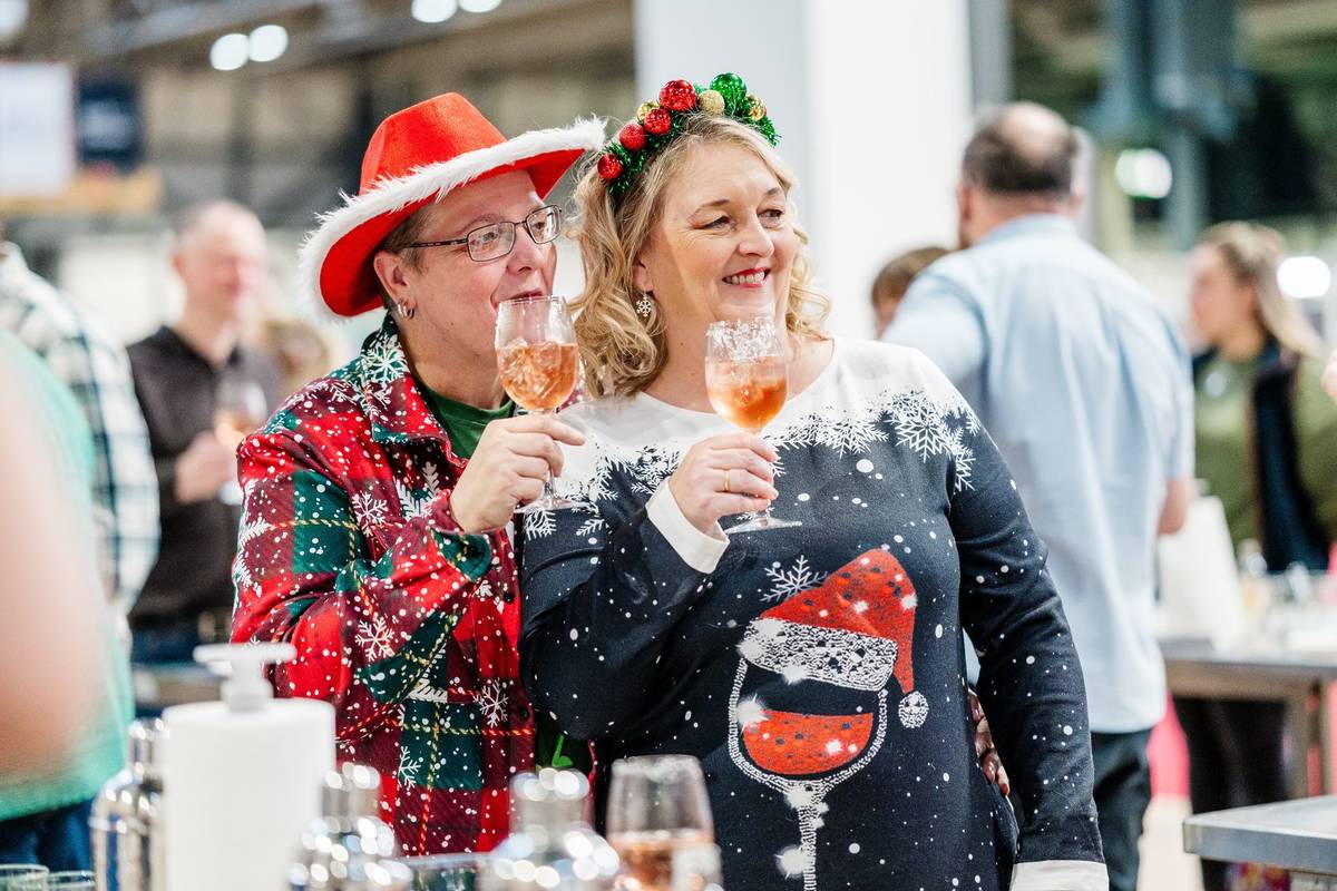 A couple dressed up for Christmas drinking cocktails at the Good Food Show