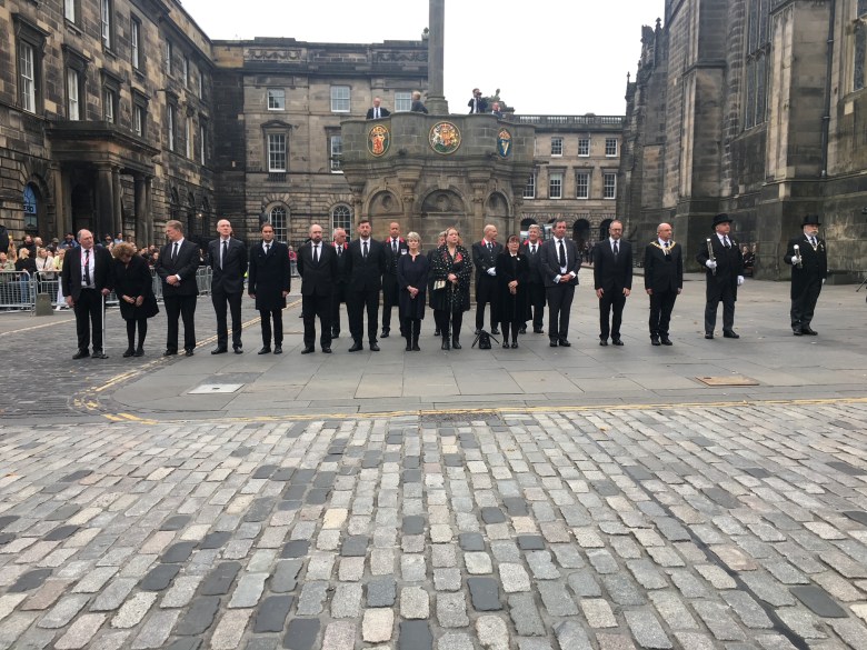 a line of people standing on the street