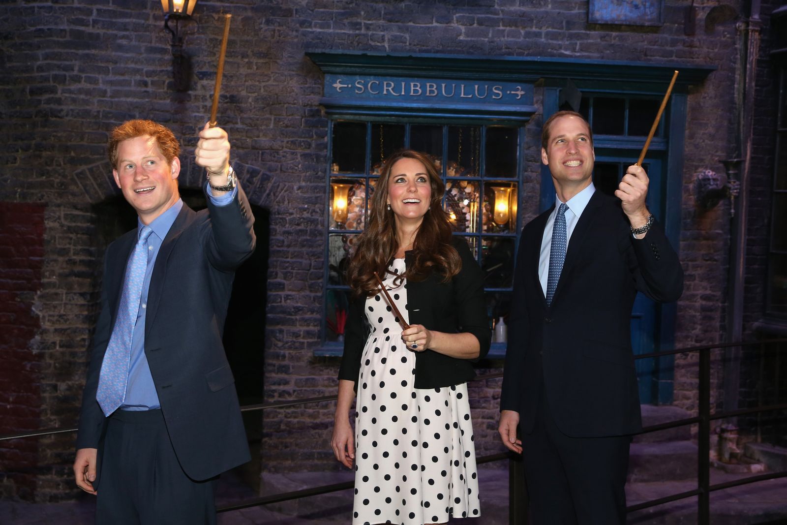Prince Harry Kate Middleton and Prince William raise their wands on the set used to depict Diagon Alley in the Harry...