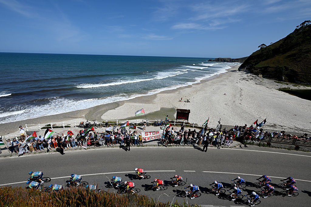 L'ANGLIRU, SPAIN - SEPTEMBER 05: (L-R) Emanuel Buchmann of Germany and Team Cofidis, Stefan Kung of Switzerland and Team Groupama - FDJ and a general view of the peloton competing while pro-Palestinians protest during the La Vuelta - 80th Tour of Spain 2025, Stage 13 a 203.7km stage from Cabezon de la Sal to L'Angliru 1556m / #UCIWT / on September 05, 2025 in L'Angliru, Spain. (Photo by Dario Belingheri/Getty Images)