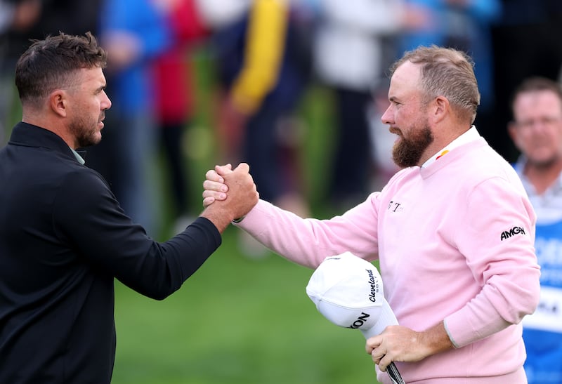 Brooks Koepka and Shane Lowry shake hands after finishing their round. Photograph: Warren Little/Getty