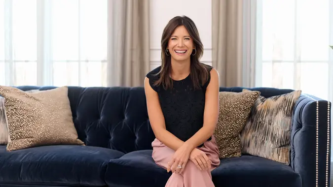 Image of Rachel Cruze smiling while sitting on blue couch