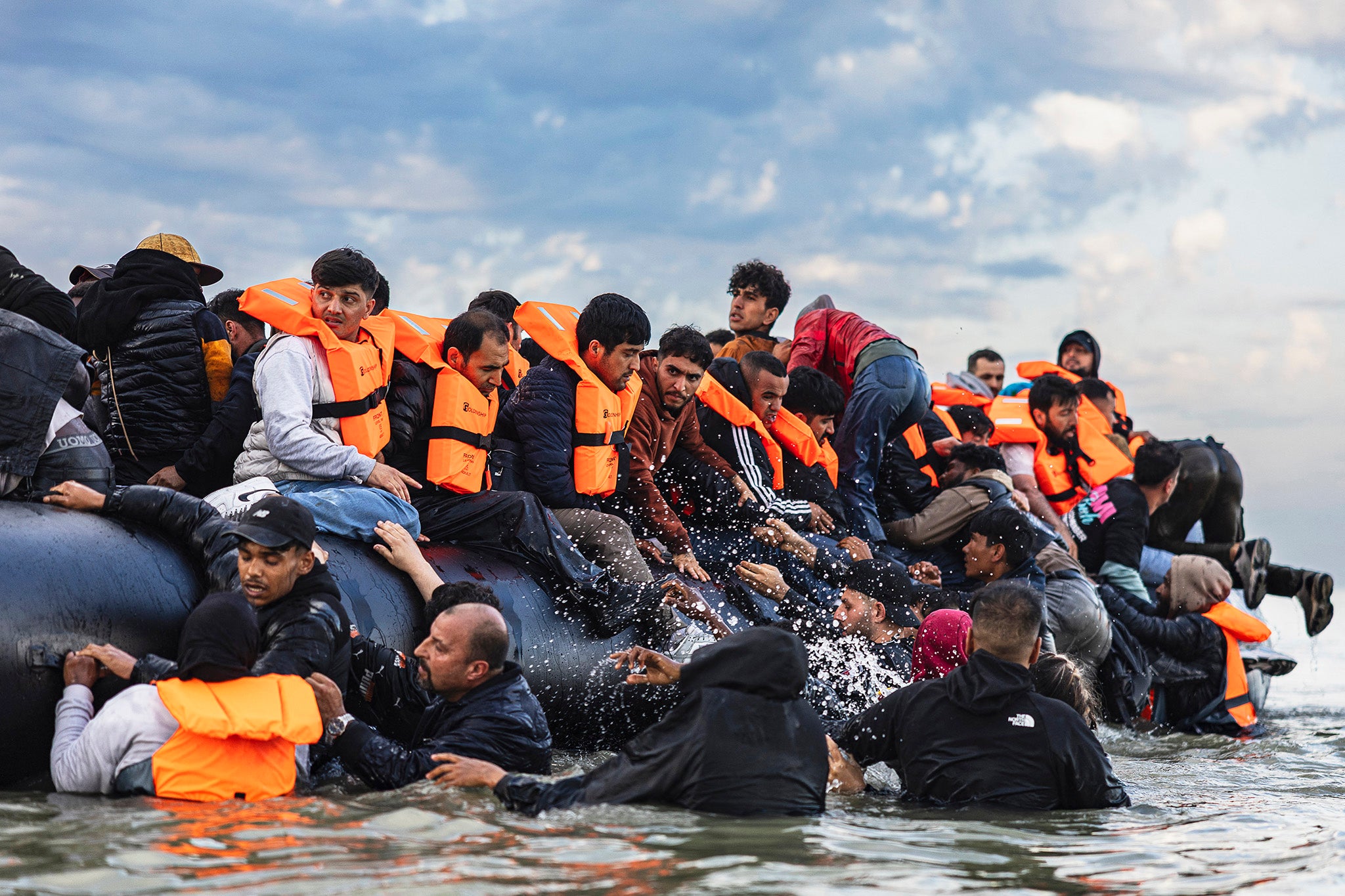 Migrants try to board a smuggler's boat in an attempt to cross the English Channel off the beach of Gravelines