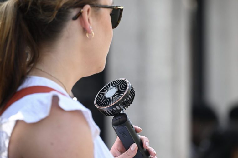 LONDON, UNITED KINGDOM AUGUST 12: A woman uses a portable fan to cool down in London as the UK Health Security Agency (UKHSA) issues an amber extreme heat health alert for East Midlands, West Midlands, East of England, London and South East on August 12, 2025. The rest of the country remains under a yellow heat warning, with temperatures expected to exceed 35??C in some areas. (Photo by Rasid Necati Aslim/Anadolu via Getty Images)