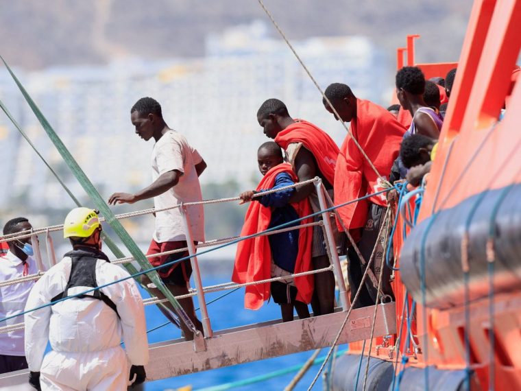 Migrants disembark from a Spanish coast guard vessel at the port of Arguineguin, on the island of Gran Canaria. Spain, August 24, 2025. REUTERS/Borja Suarez