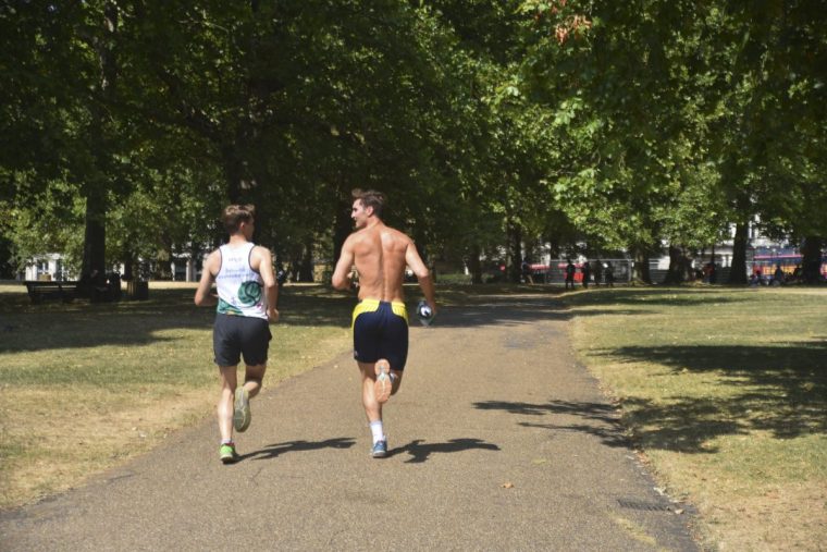 Visitors to Green Park Run on the dry brown grass in London on July 24, 2018. Parts of the UK are experiencing more heatwave conditions, with temperatures heading towards 32C (90F) and set to rise higher later this week. (Photo by Alberto Pezzali/NurPhoto via Getty Images)