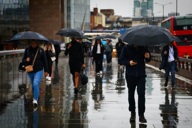 LONDON, ENGLAND - AUGUST 29: Members of the public walk through the rain over London Bridge on August 29, 2025 in London, England. The Met Office has issued a yellow weather warning for heavy rain in southern parts of England today, forecasting 50-70mm of rain falling in just a few hours. (Photo by Alishia Abodunde/Getty Images)