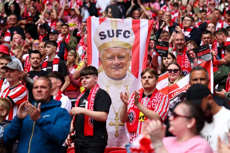 LONDON, ENGLAND - MAY 24: A fan of Sheffield United holds up a flag featuring Chris Wilder the head coach / manager of Sheffield United dressed up as The Pope during the Sky Bet Championship Play-Off Final match between Sheffield United and Sunderland at Wembley Stadium on May 24, 2025 in London, England. (Photo by Robbie Jay Barratt - AMA/Getty Images)
